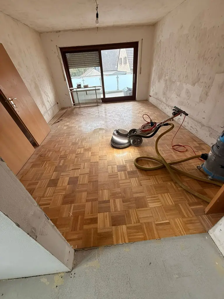 Parkettboden mit Schleifmaschine während der Renovierung
